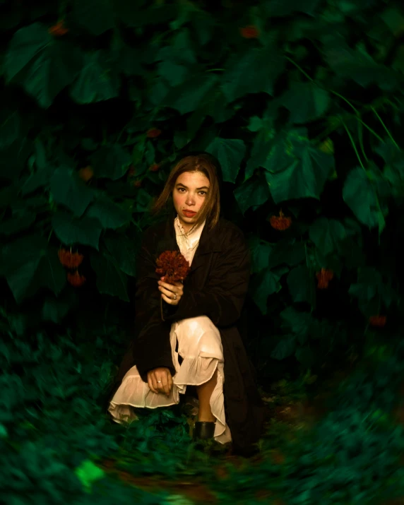 the woman in the black coat is holding a bouquet of flowers