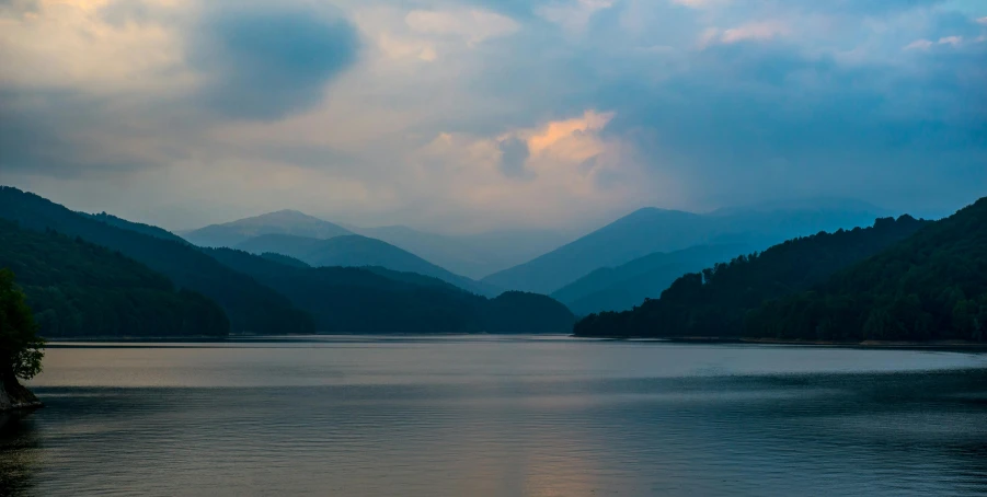 a view of a lake surrounded by mountains in the distance