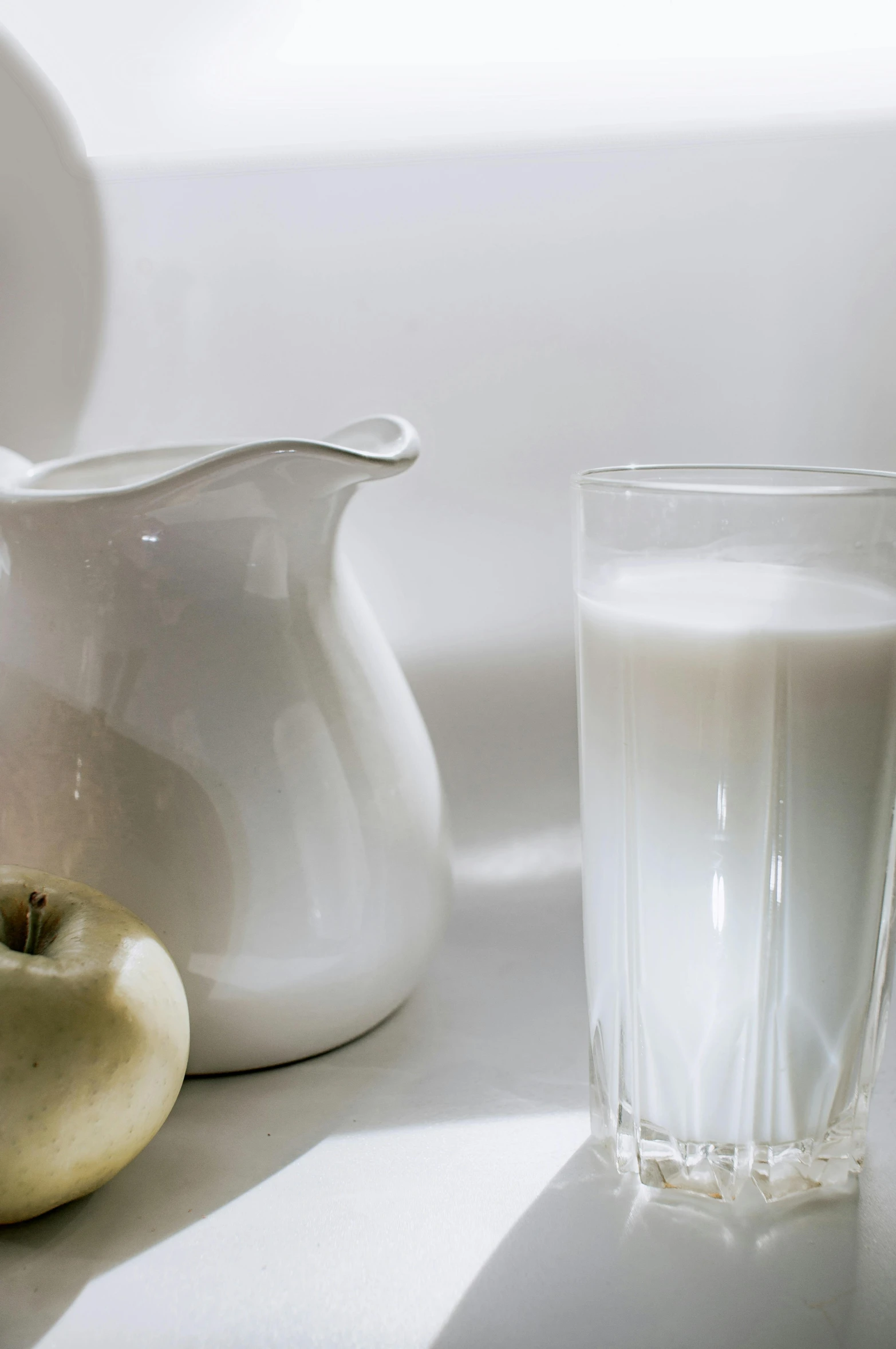 an apple next to some glass of milk