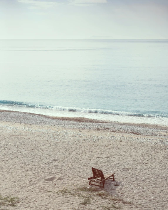 a park bench near the ocean with an empty field nearby