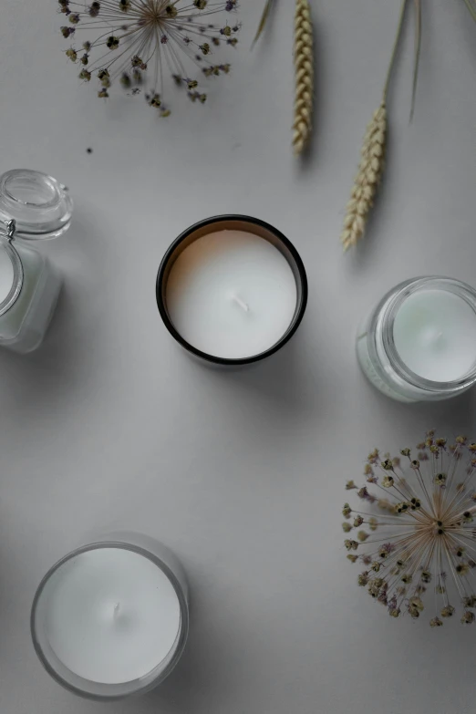 an arrangement of flowers and some candles on a table