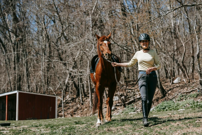 a woman wearing full equestrian clothing stands in front of a horse