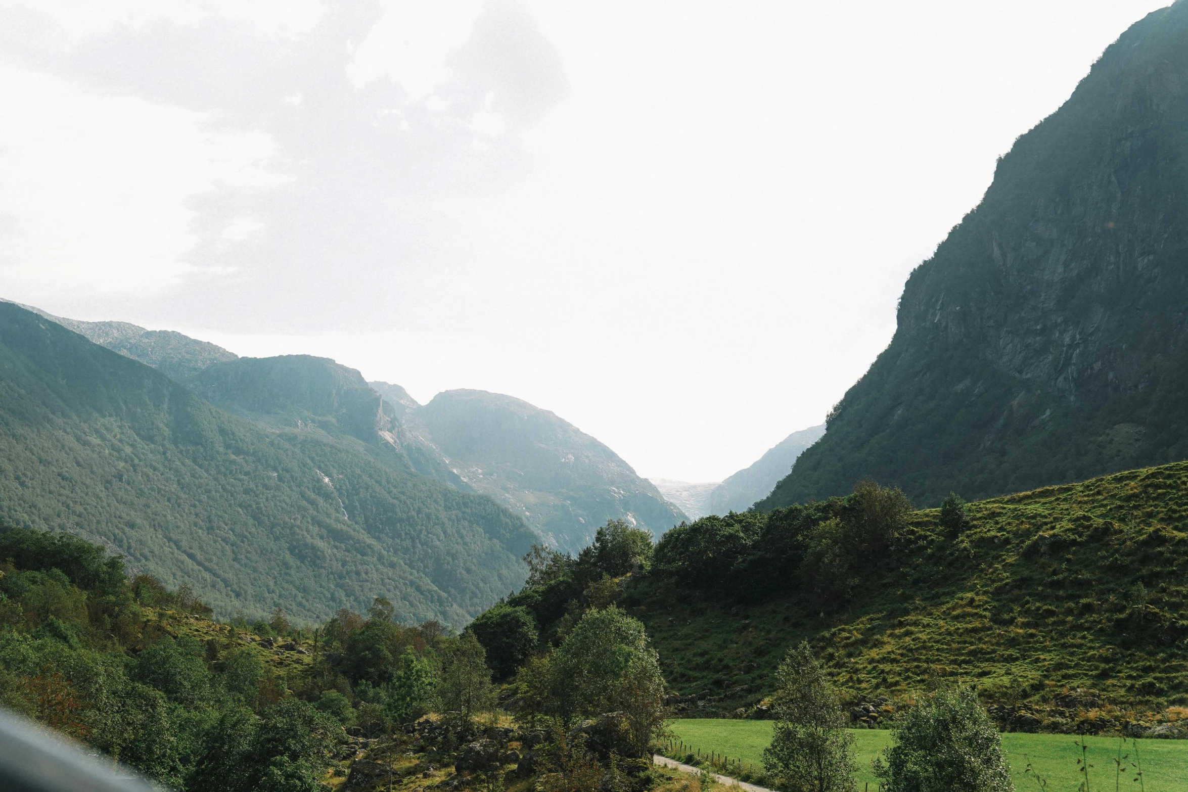 a scenic view of mountains with green fields