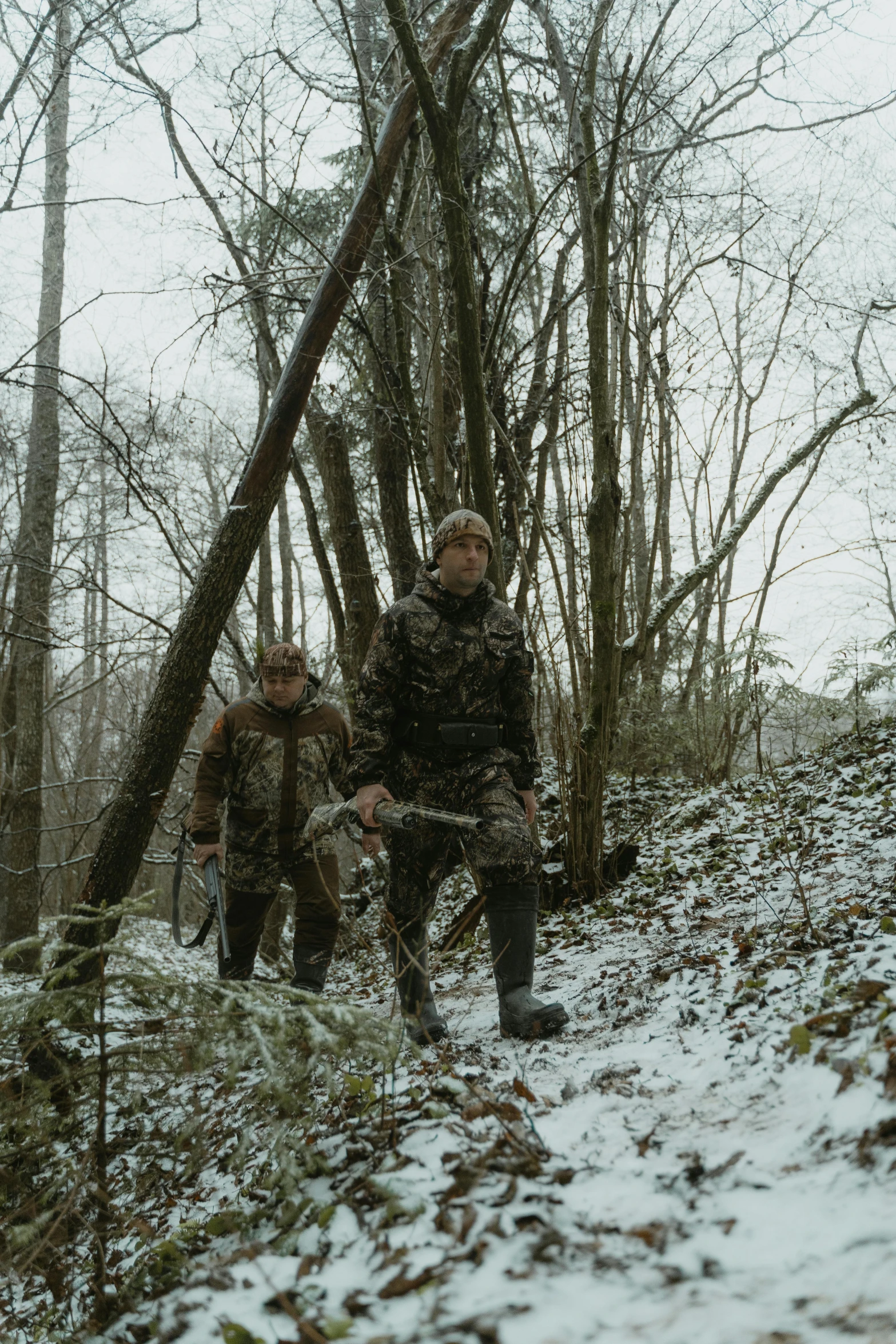 the man in camouflage is holding a gun while other men are walking