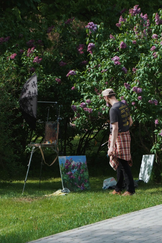 a man with an umbrella looks at a painting