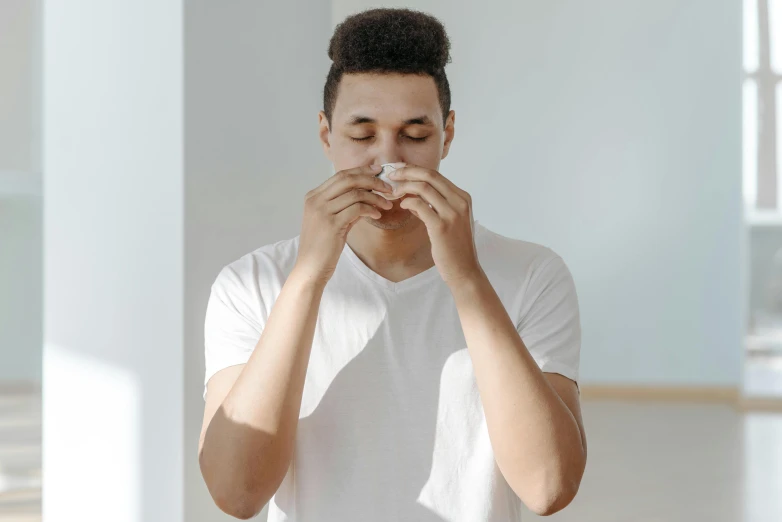 a young man is blowing his nose and holding a napkin in his hand