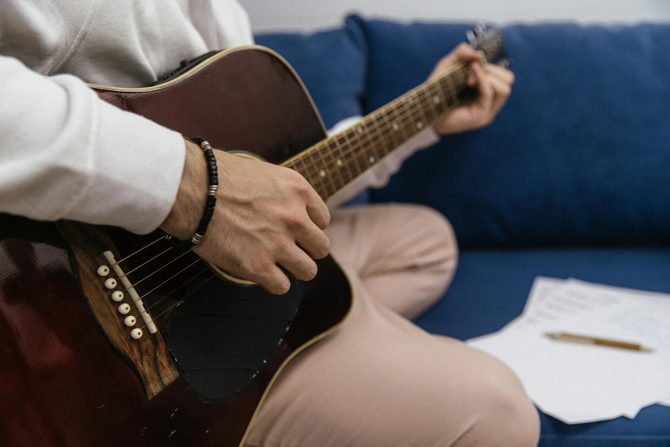 a person sitting on the floor playing a guitar