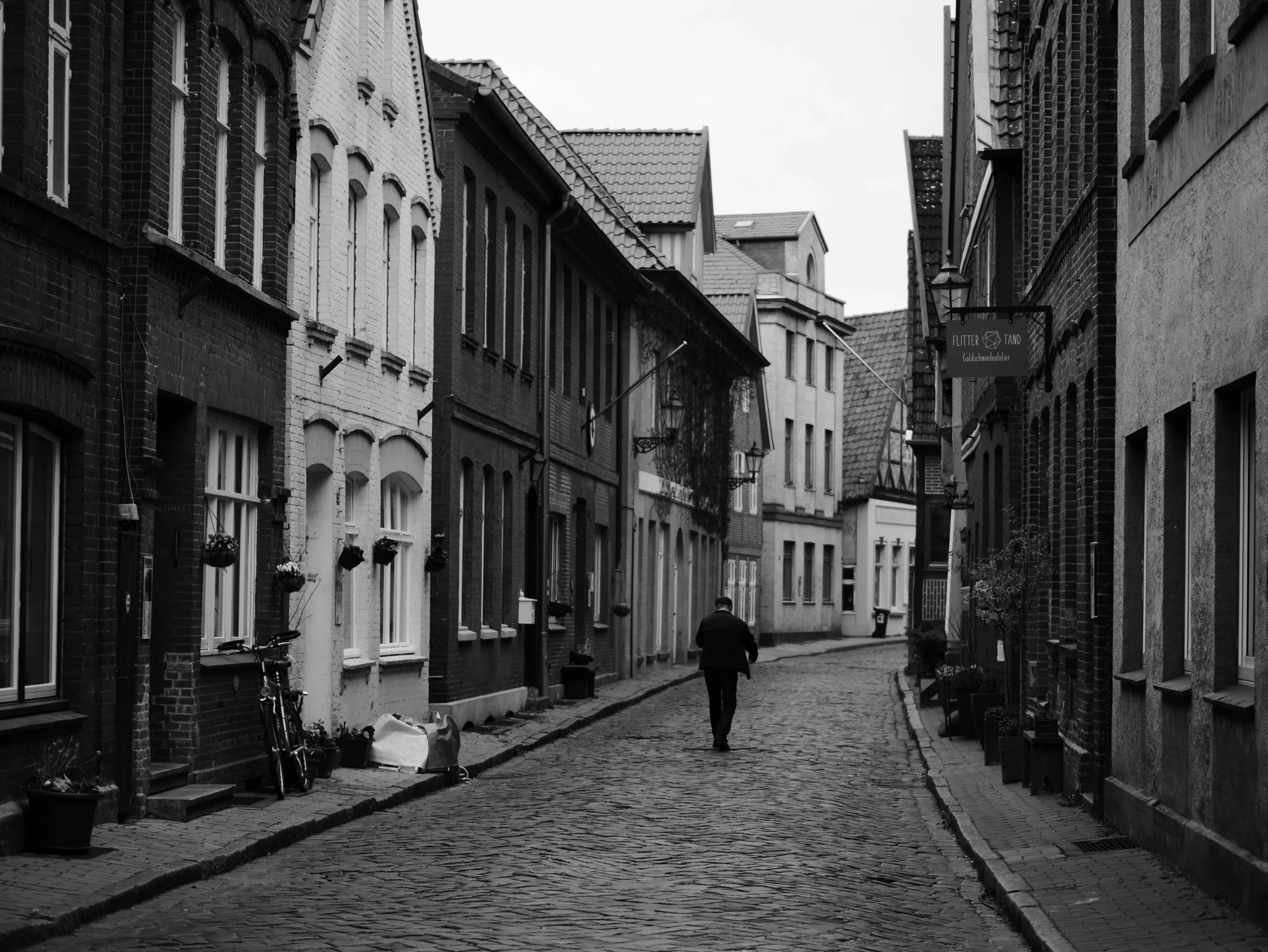 a person walks down a cobblestone street in an old city