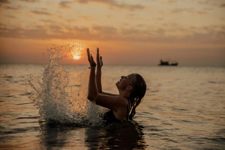 the girl is throwing the frisbee in the water