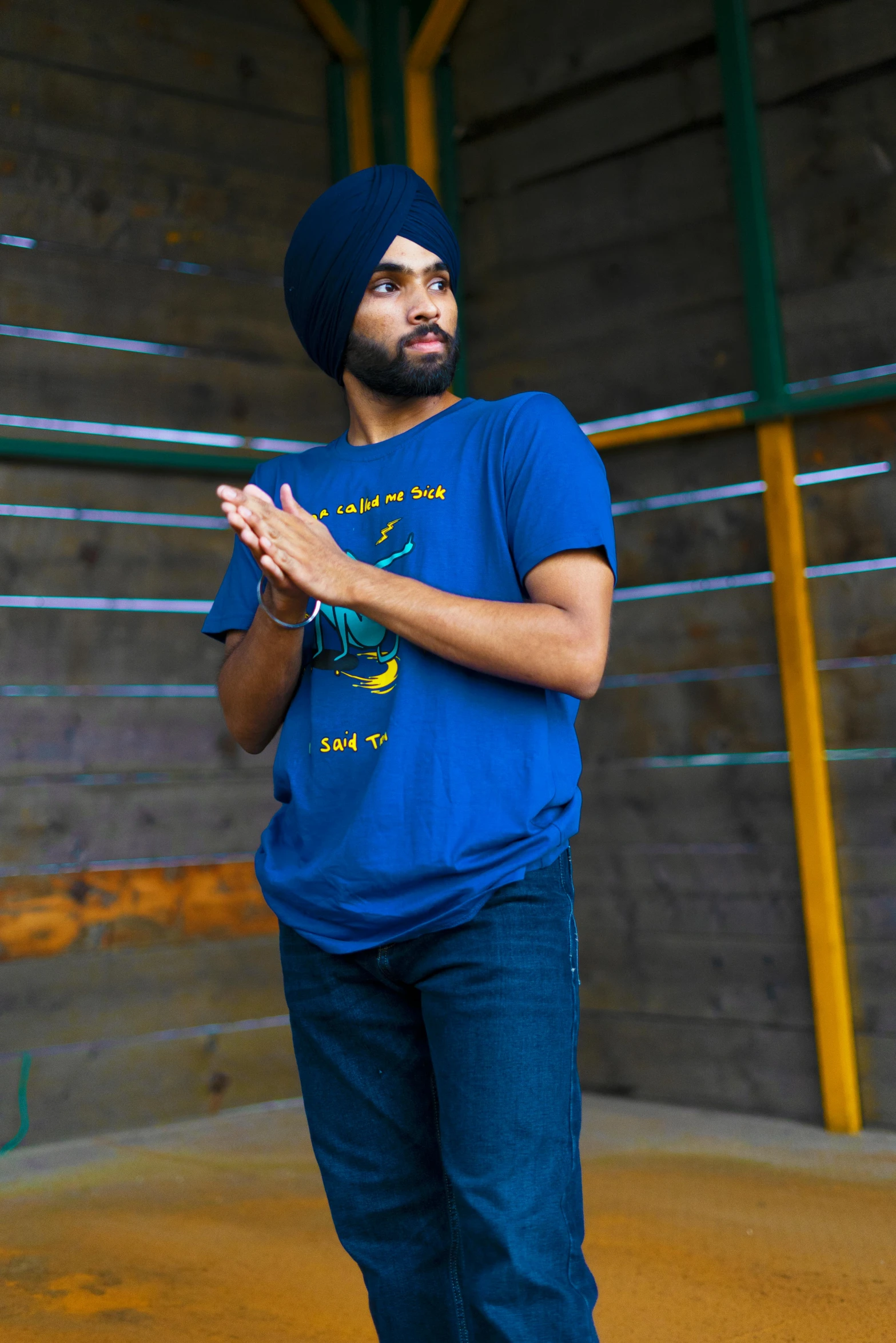 man with blue turban standing in front of a fence