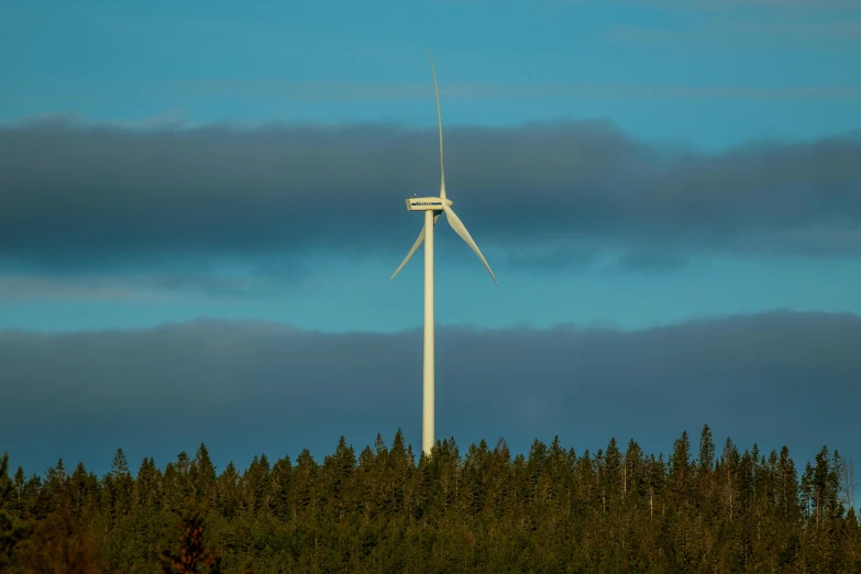 a large wind turbine is in the air near trees