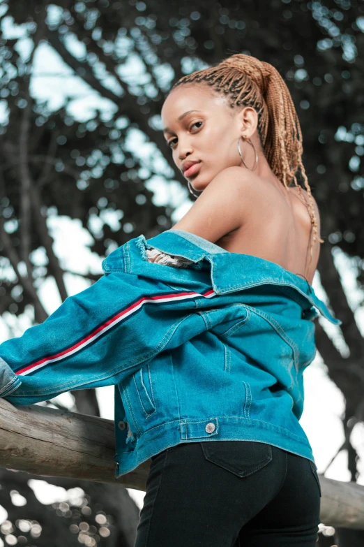 a black girl in a blue jacket looks at the camera