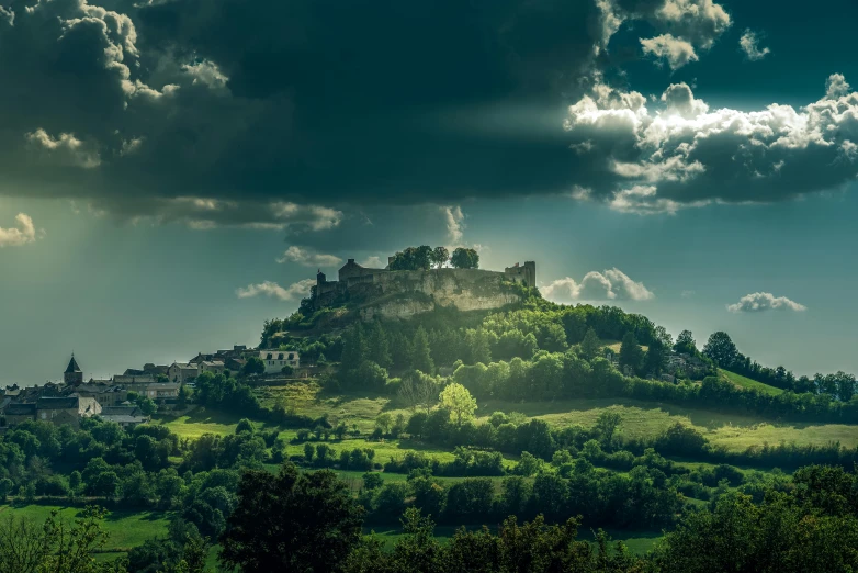 the sun is shining over the castle on top of a hill