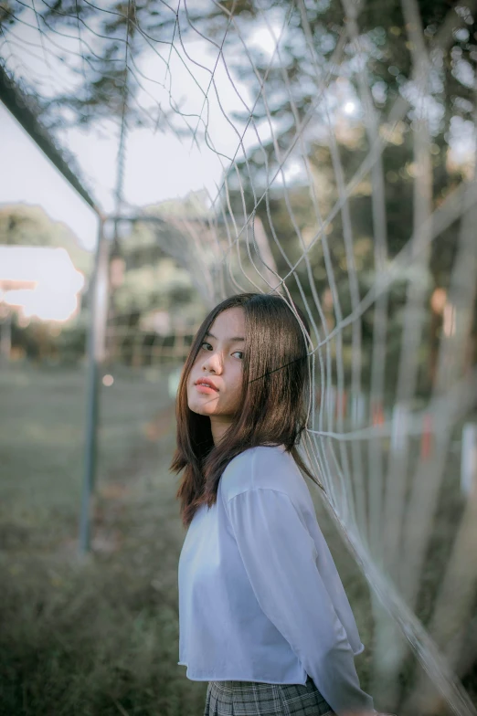 woman standing under a hanging net looking off into the distance