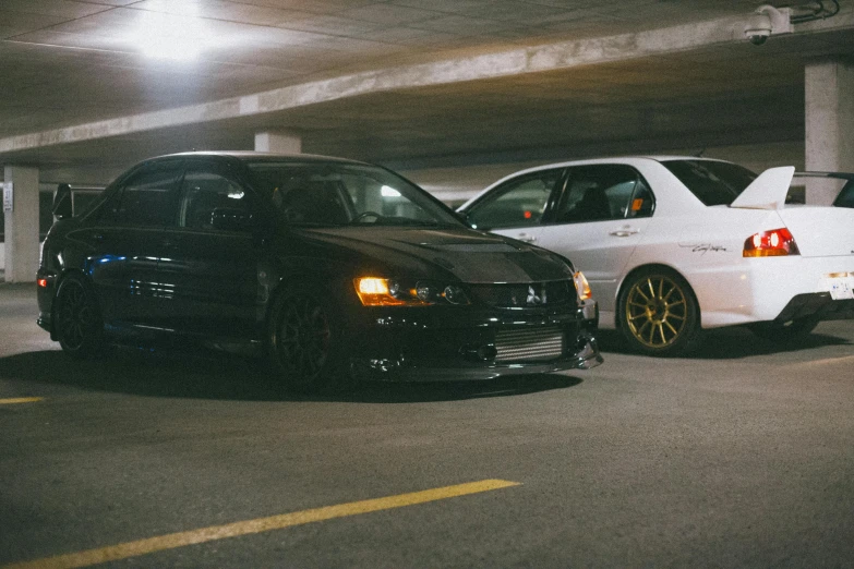 two white cars sit in a parking lot