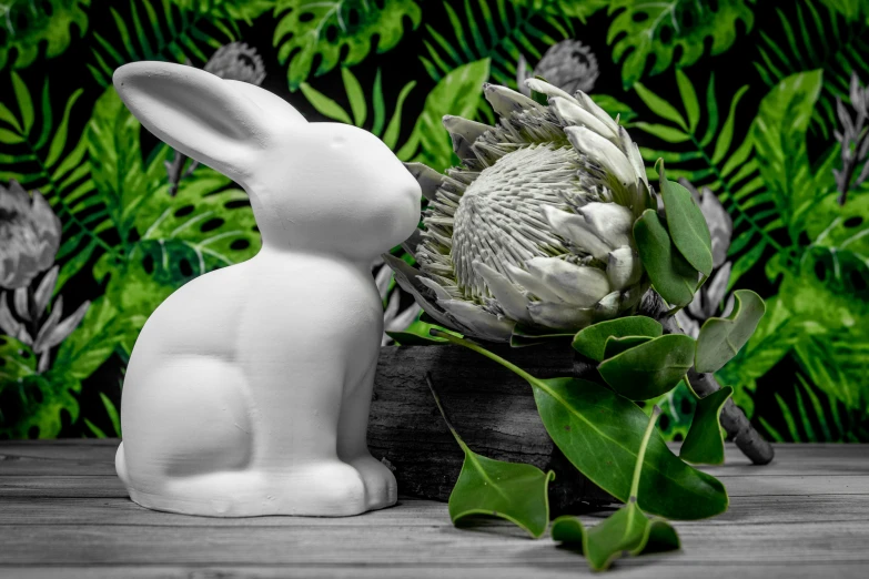 an artful statue of a white bunny and a plant