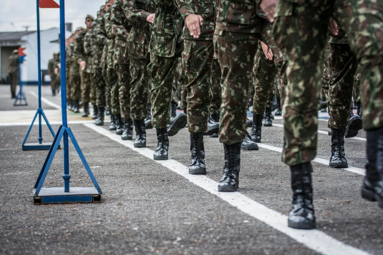 some army personnel are marching past the camera