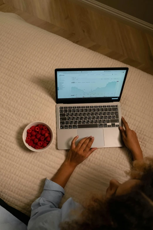 a woman is on her laptop while eating pet food