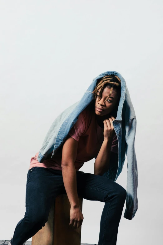 a person sitting down with his head on the back of a skateboard