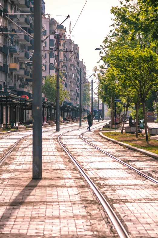 a lone person on a walkway in the middle of a city