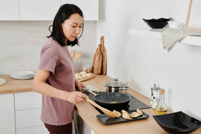 a woman stands in the kitchen to prepare food