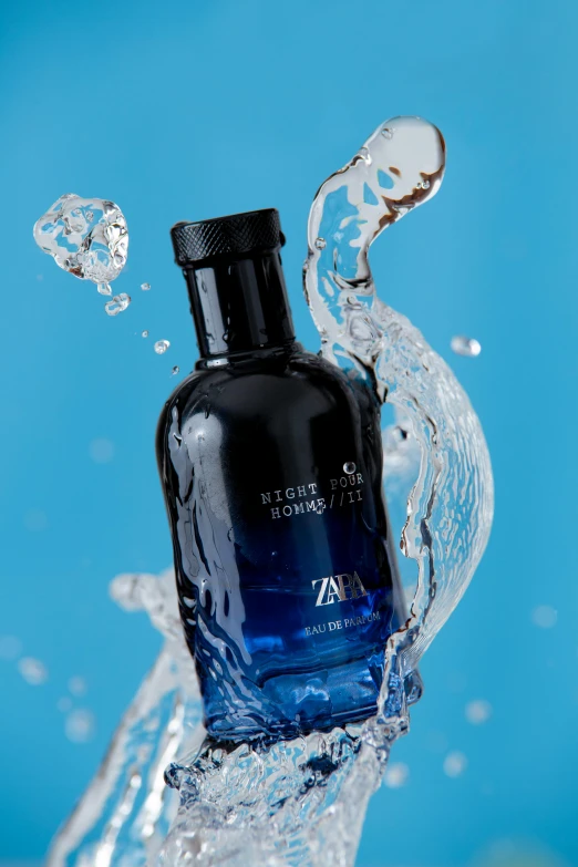 a close - up s of an empty blue bottle with some water splashing around