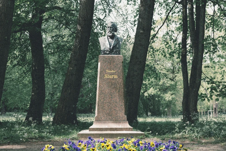 there is a small memorial sitting in the middle of some flowers