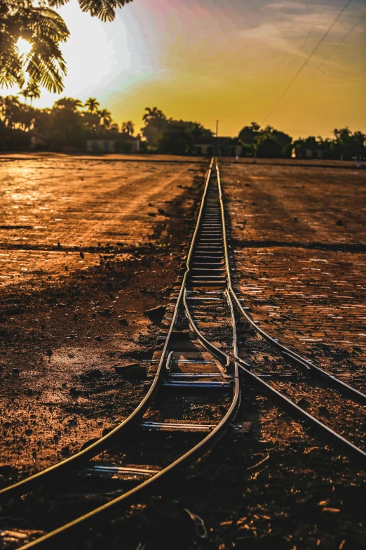 a train track with the sun shining on it