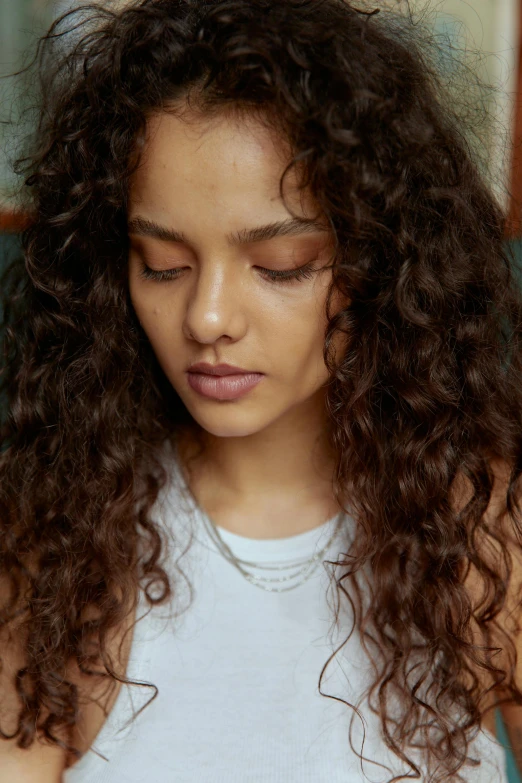 a woman with frizz on her hair holding a phone