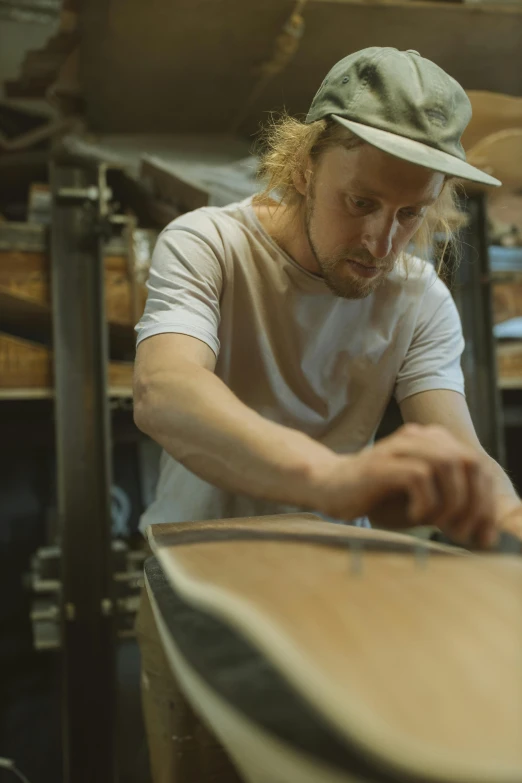 a young man working on a wooden object