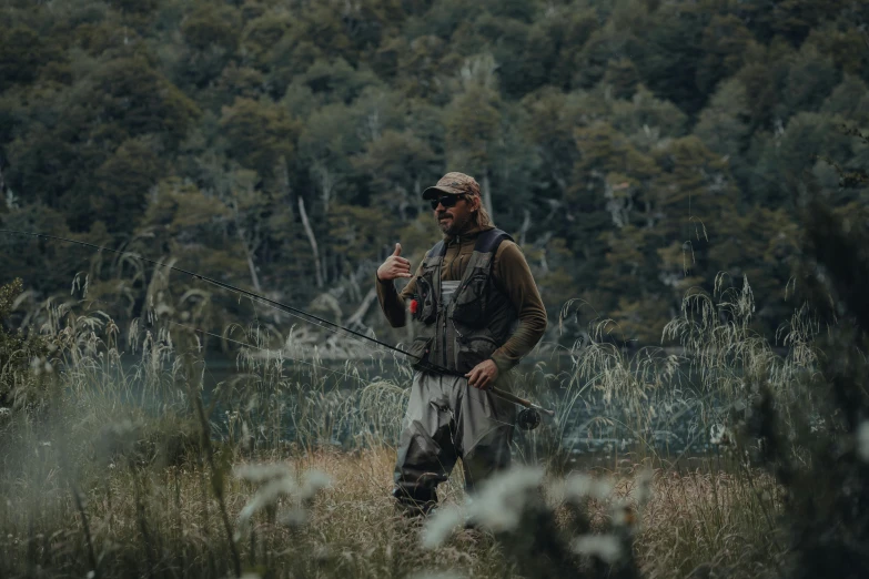 a man stands in the forest with a fishing rod