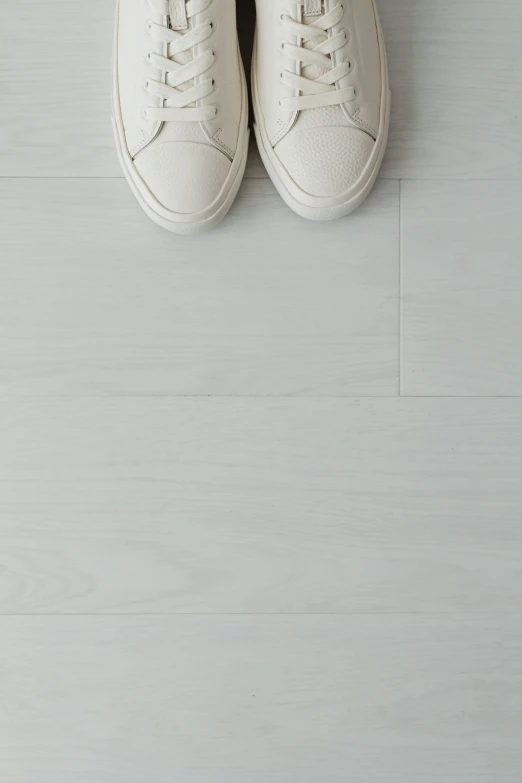 a white pair of shoes is sitting on a floor