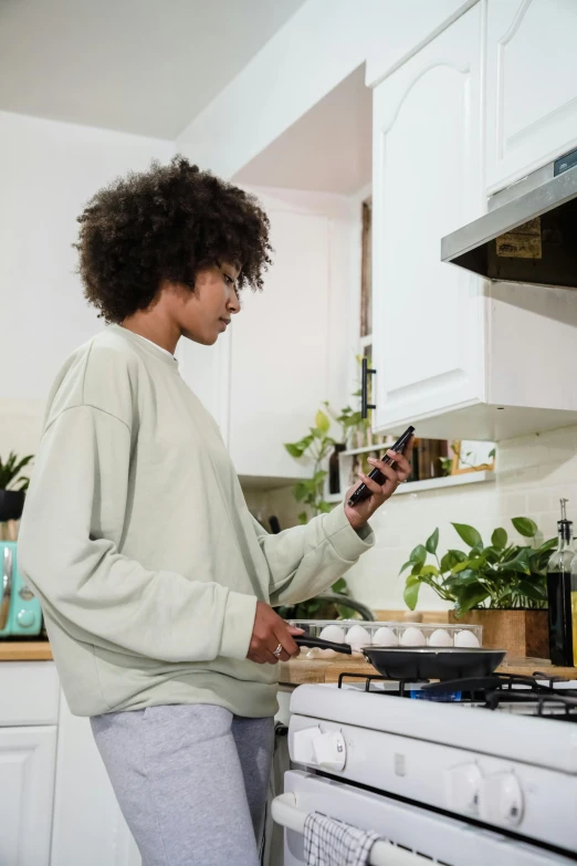 a woman standing at a stove in a kitchen