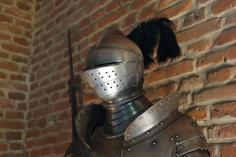 a large iron armor standing next to a brick wall