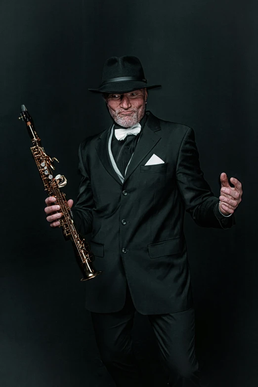 the man is dressed in a suit and holding his trumpet