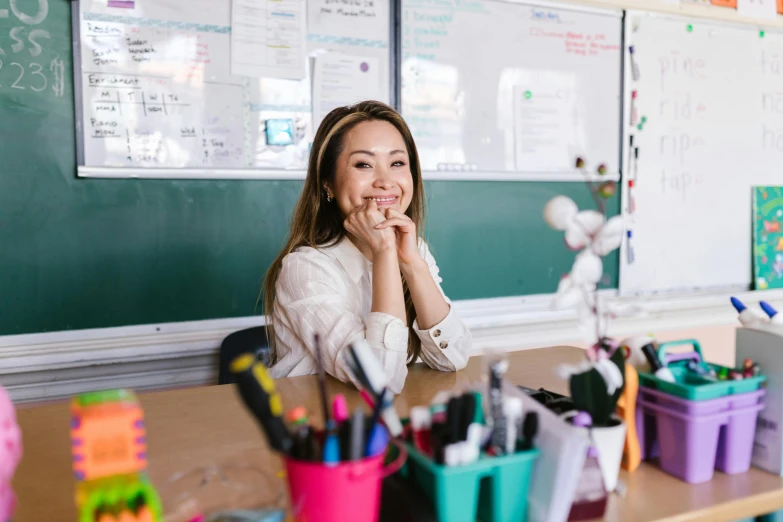 a girl in a classroom smiles for the camera