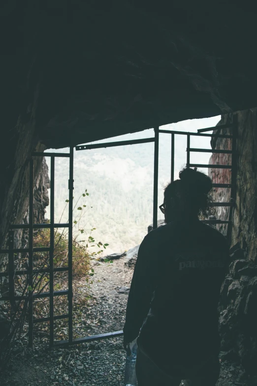 two people look out the open door of an old wooden building