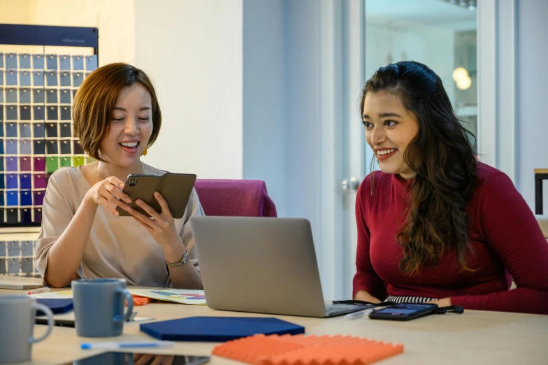 two women at a table with their computers