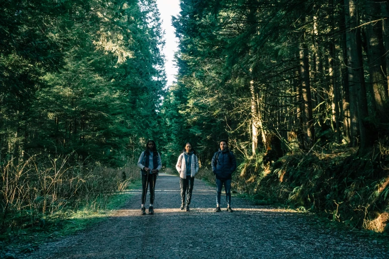 three men walking down a trail in the woods