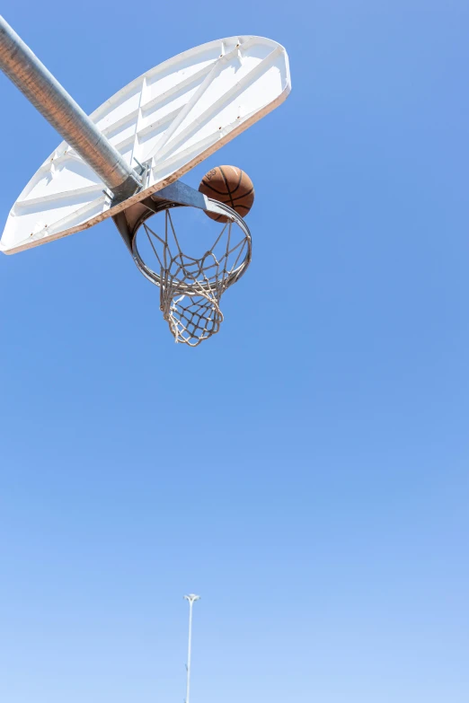 basketball net with a basket above it with an athletic ball in the hoop
