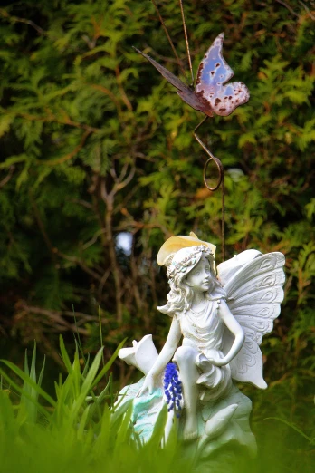 a statue of a fairy with blue wings