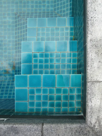 the wall with many tile squares is blue and grey
