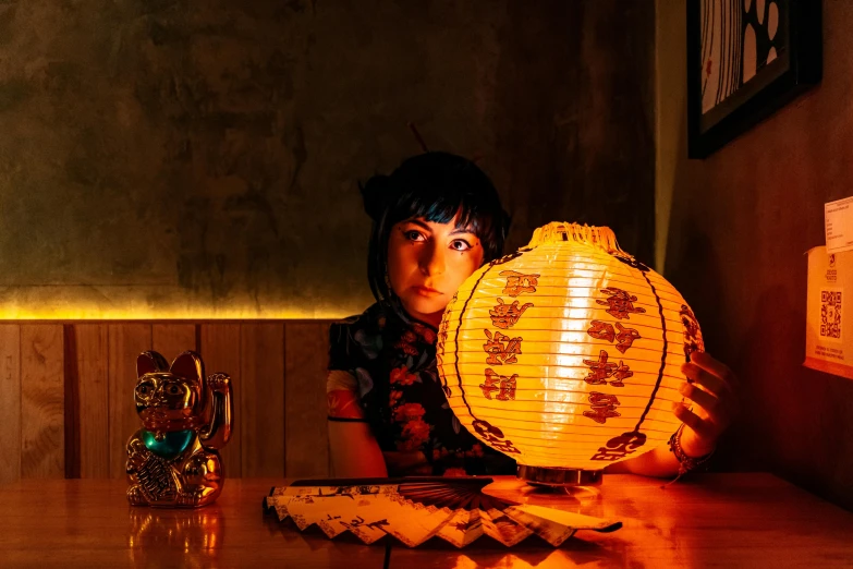 a boy holding a chinese style lamp with red lights on it