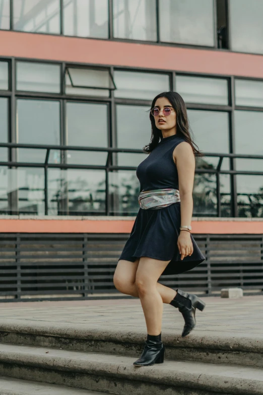 woman in black dress and cowboy boots walking up some steps