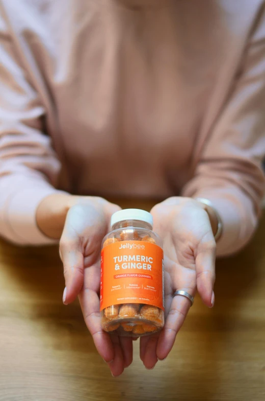 a person holding an orange glass bottle filled with pills