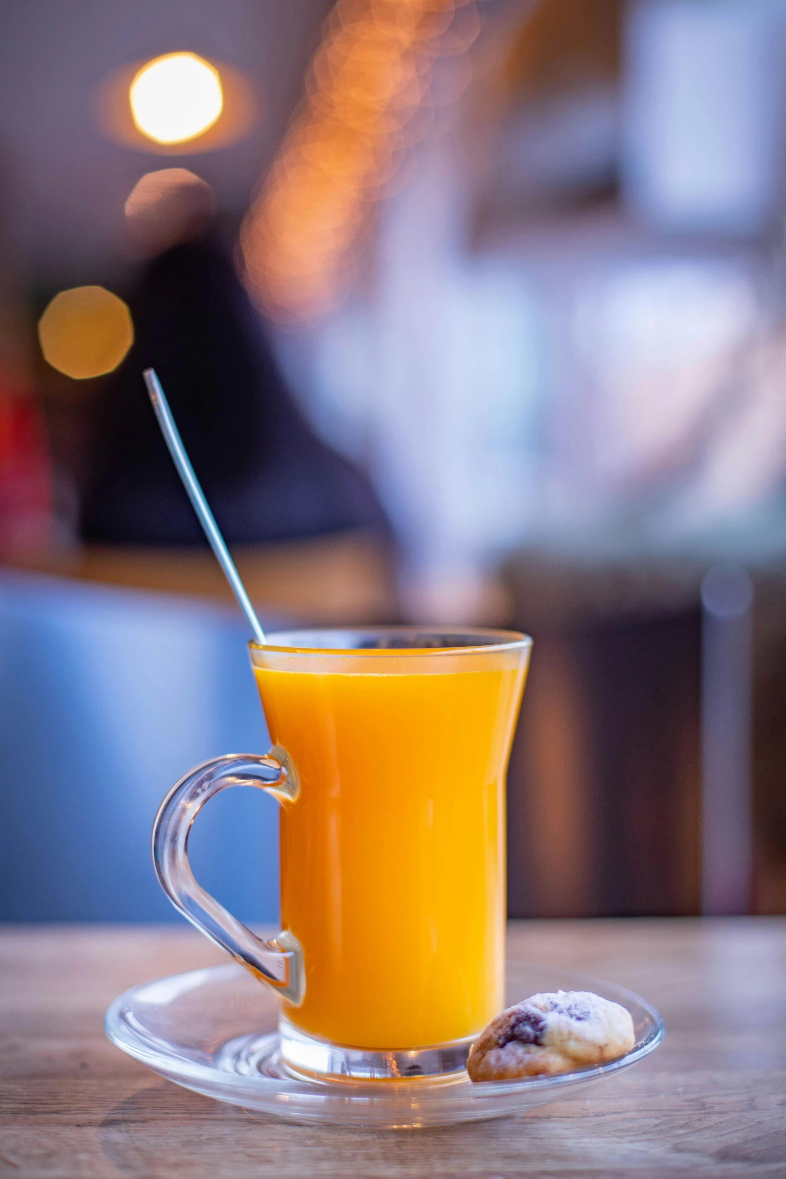 a glass cup with juice and a metal stick