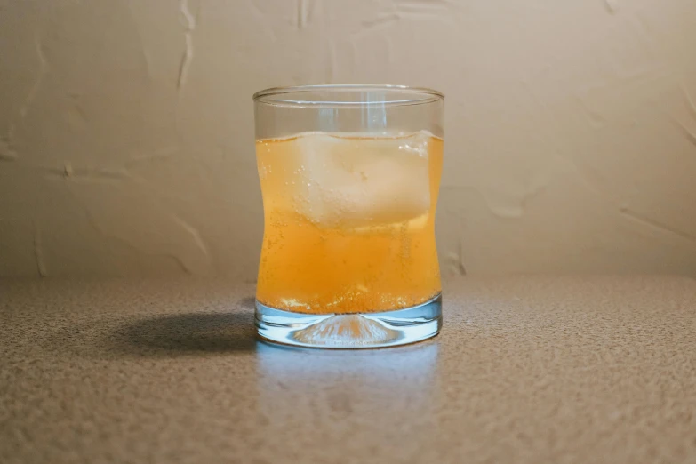 a glass of juice sitting on a counter