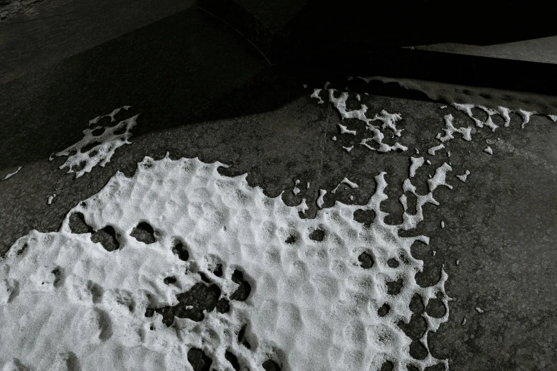 snow that is on a sidewalk and black and white pograph