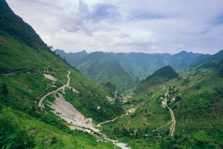 a narrow winding mountain road that goes through lush vegetation