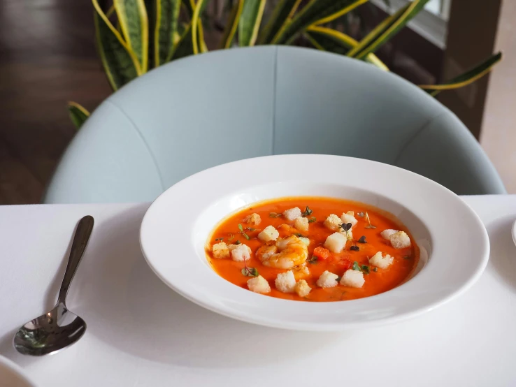 a bowl of carrot soup with white marshmallows in it